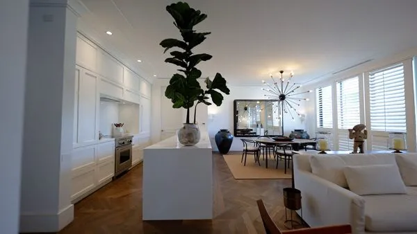 Cocina blanca con isla central y comedor moderno integrados en un espacio creado por un arquitecto en Monterrey top