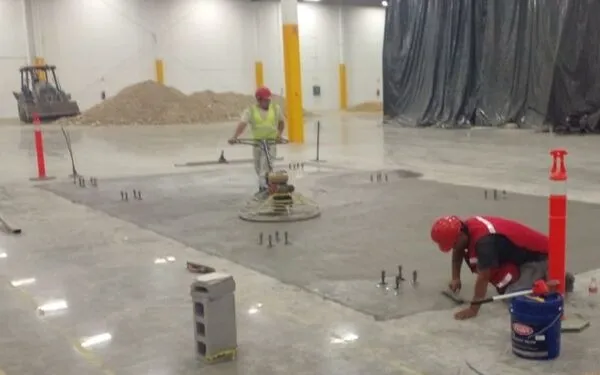 Trabajadores realizando pulido de pisos industriales en proyecto dirigido por arquitectos en Tijuana Baja California norte