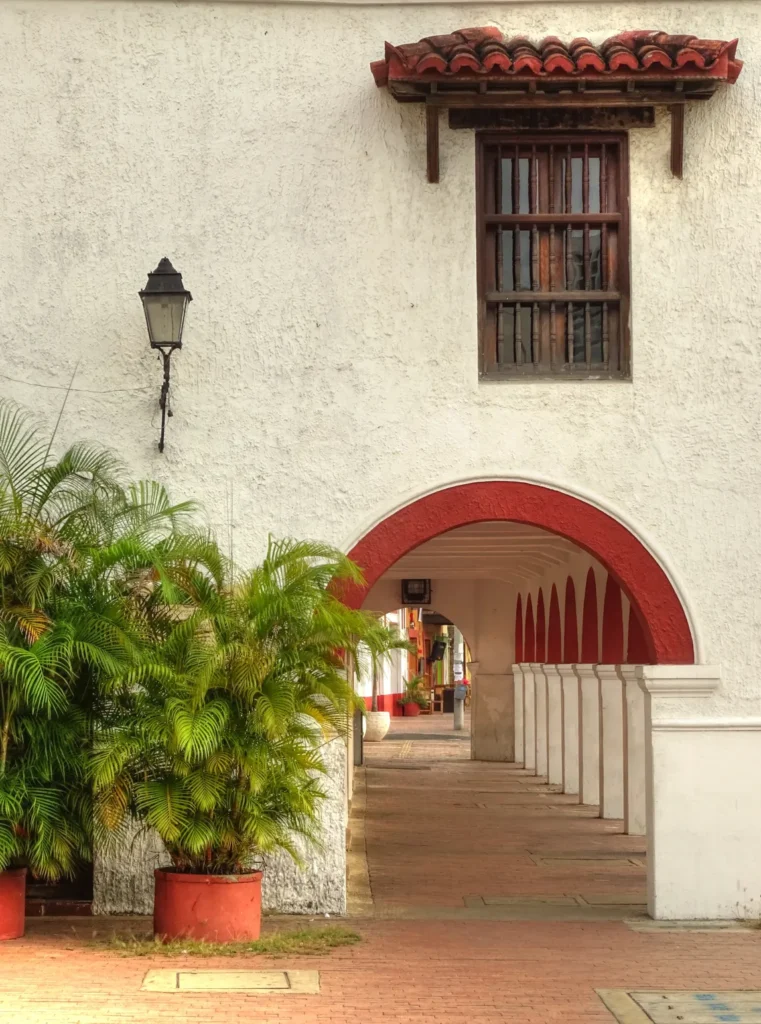 Ejemplo de arquitectura en Cancún, Quintana Roo con pasillos de arquería, macetones y una ventana de estilo antiguo.