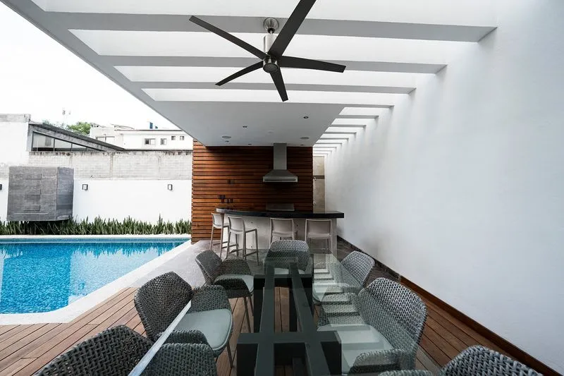 Lujosa zona de entretenimiento exterior con pérgola cocina y piscina contacte para remodelación de terrazas y jardines