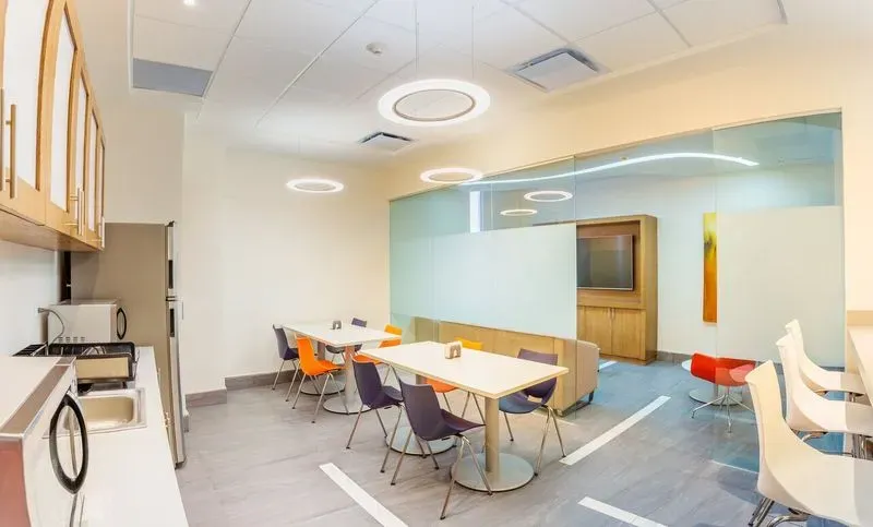 Comedor de empleados vibrante en oficinas diseñadas por una constructora de oficinas.