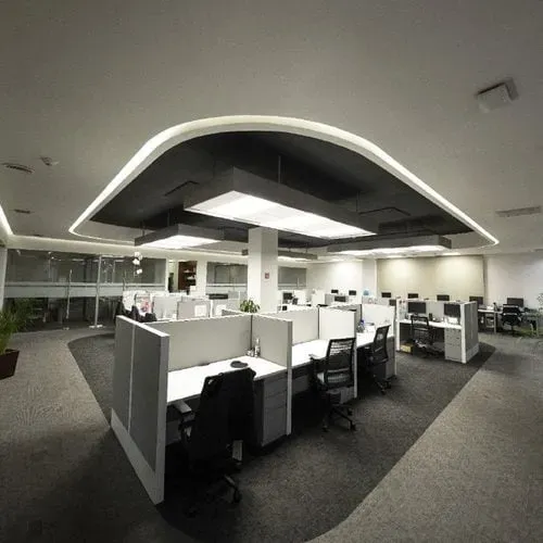 Espacio de oficinas corporativas de un despacho de arquitectos con módulos de trabajo y techo de diseño curvo.
