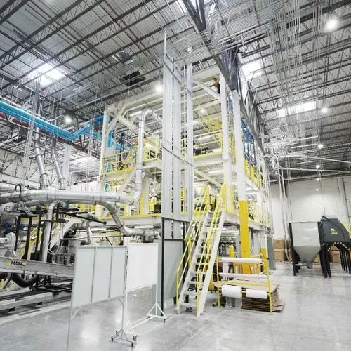 Planta industrial diseñada por un despacho de arquitectos, mostrando estructuras metálicas y pasos elevados.