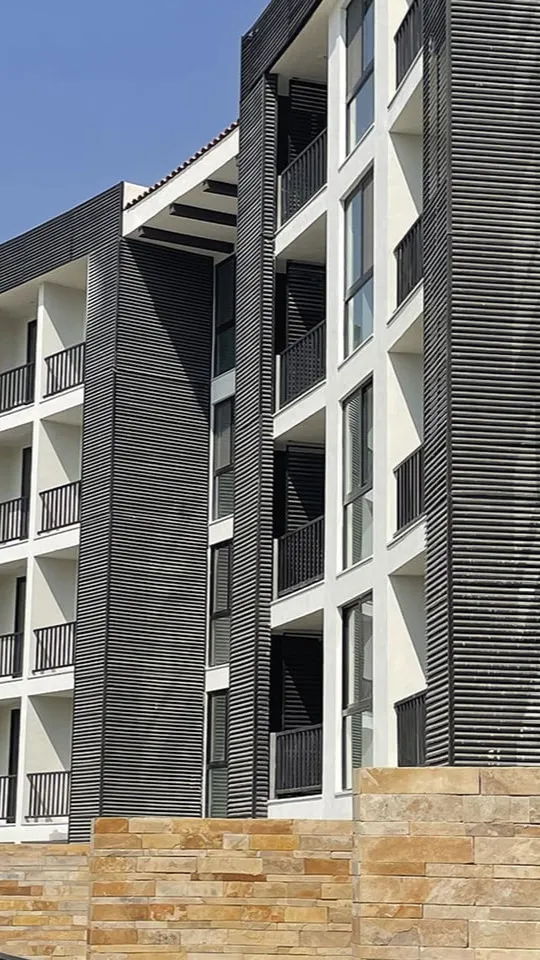 Comedor residencial con una elegante lámpara dorada de diseño exclusivo creada por un despacho de arquitectos.