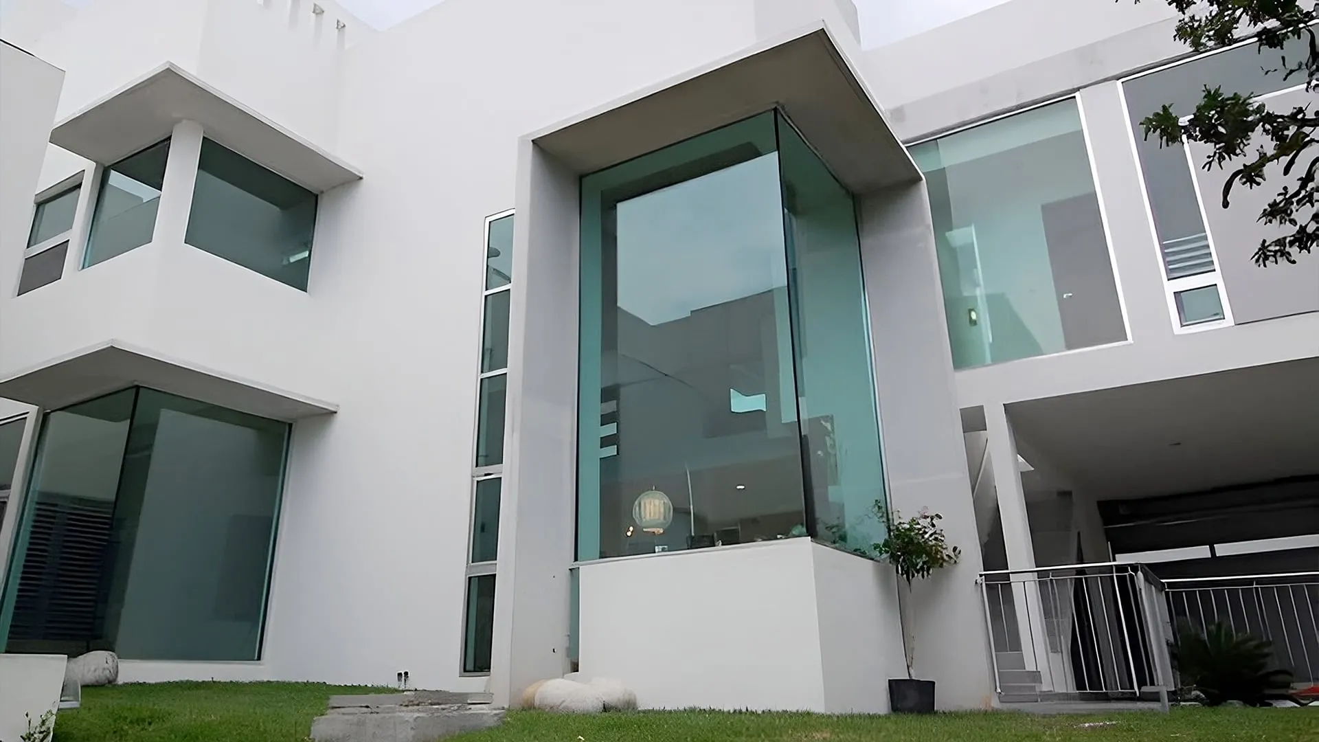 Moderna residencia minimalista de color blanco con grandes ventanales, obra de un despacho de arquitectos.