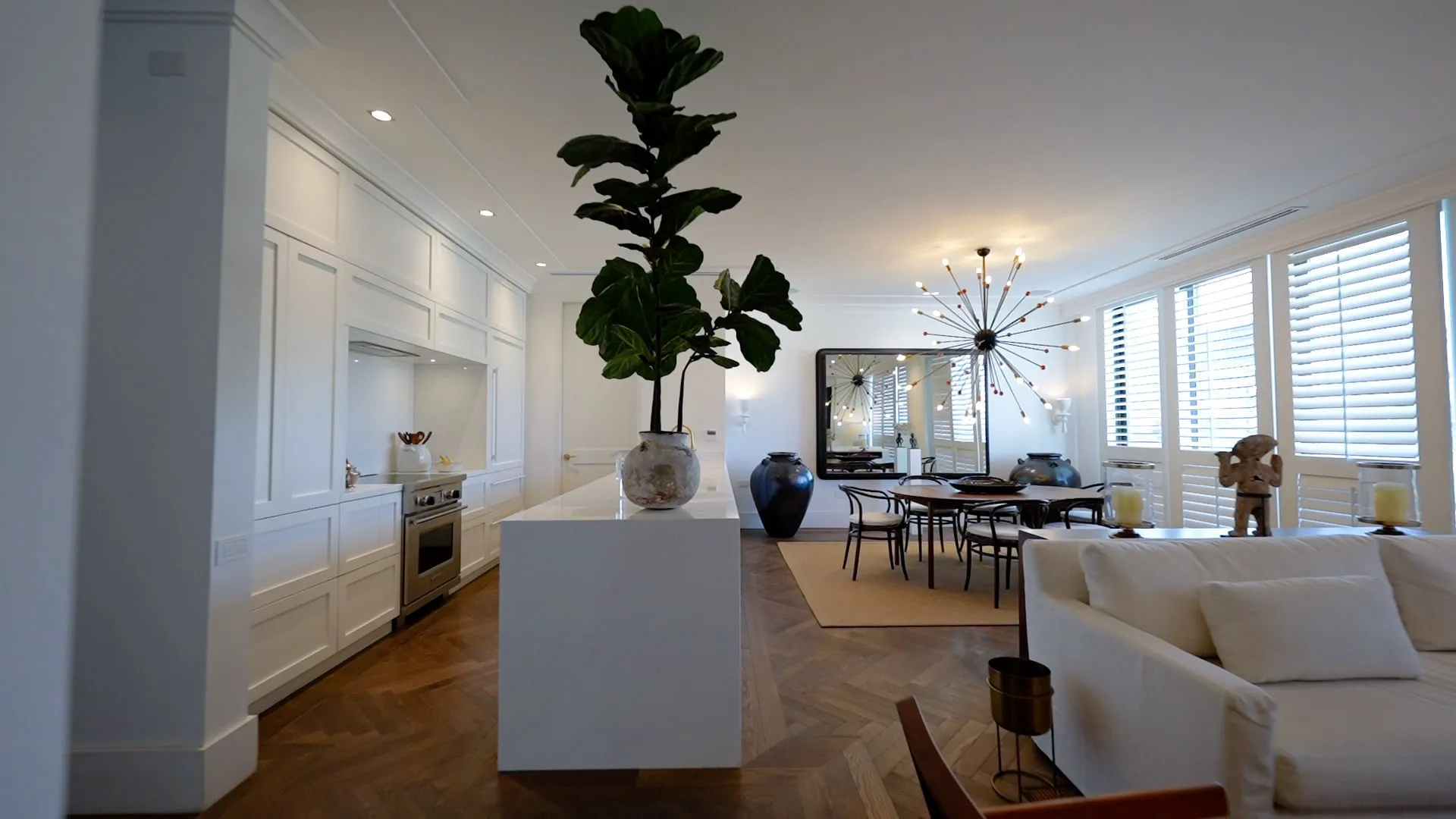 Interiores de una residencia de lujo con cocina blanca y sala de estar, proyecto de un despacho de arquitectos.